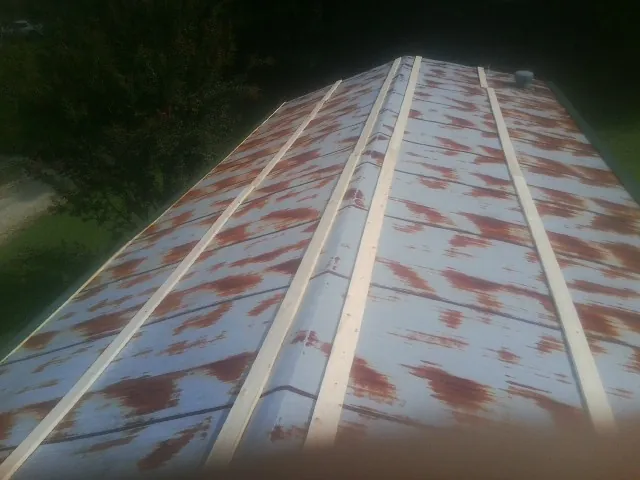 Rusted metal roof panels with new wood purlins before replacement — Storm Damage Roof Repair in Jeanerette by Roofing Brothers
